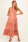 woman wearing a dusty rose maternity maxi dress with ruffle details and a visible baby bump