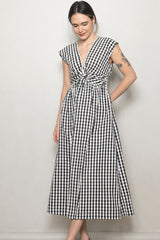 woman wearing a black and white checkered maxi dress with a knotted front and cap sleeves