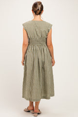 woman wearing a green and white checkered maternity dress with a smocked waist, showing the back design