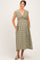 woman wearing a green and beige gingham maternity dress with a tie front and pockets, showing her baby bump