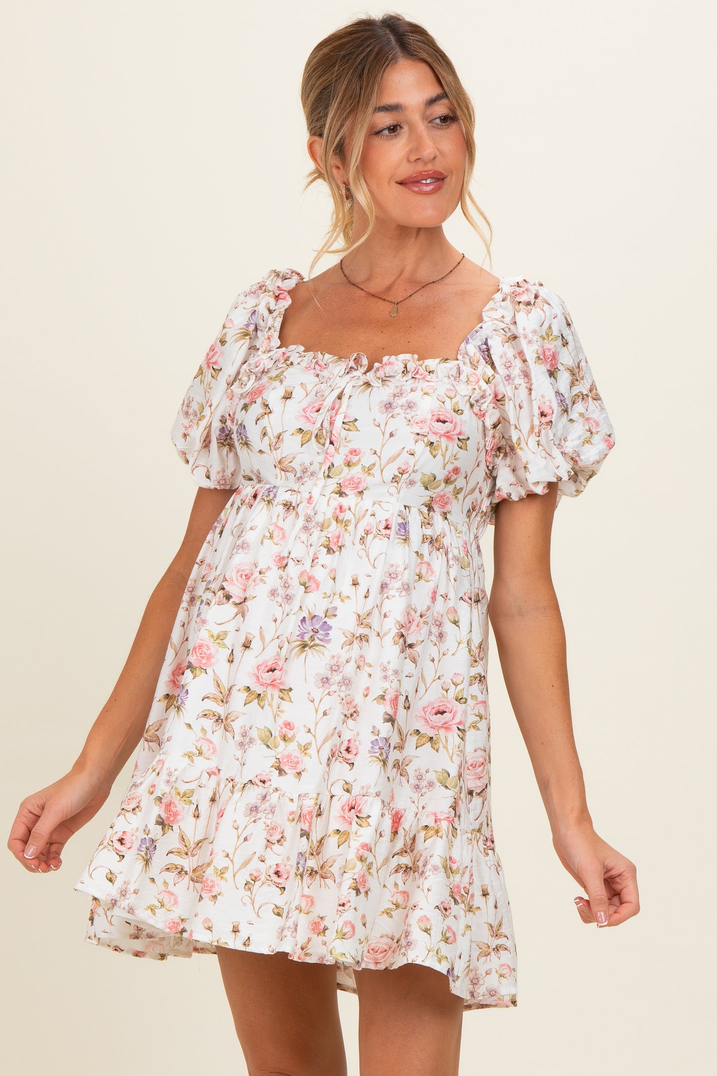 woman wearing a floral print white maternity dress with puff sleeves and a square neckline