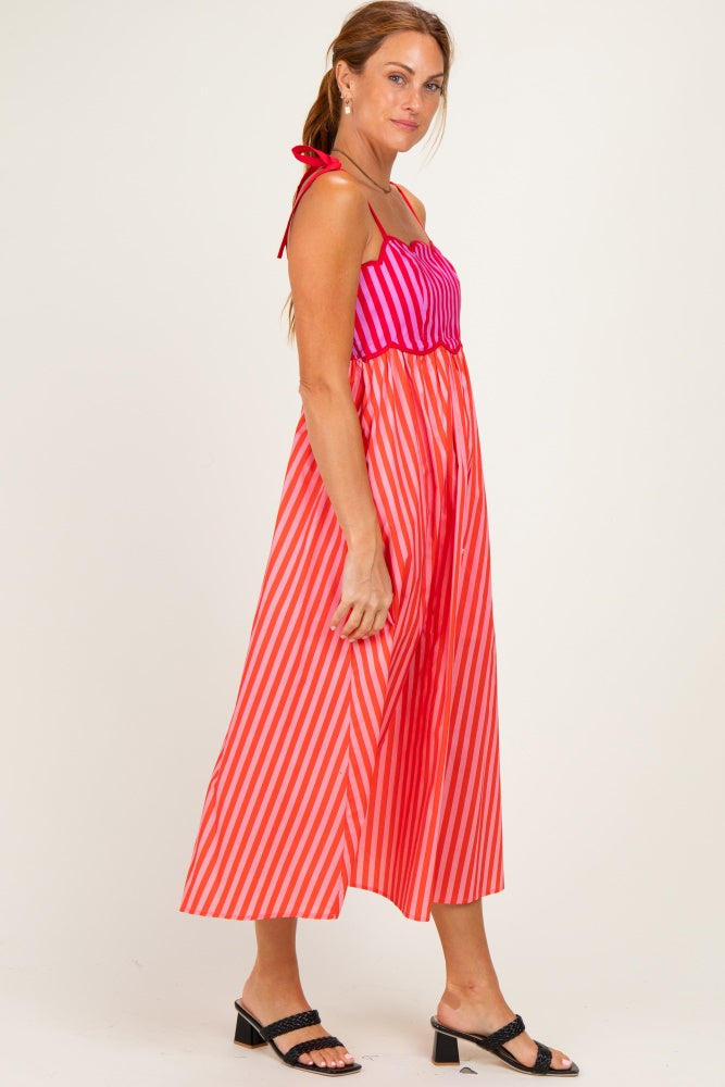 woman wearing a pink and red striped maxi dress with tie straps and a cinched waist