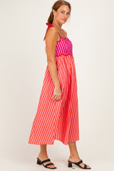 woman wearing a pink and red striped maxi dress with tie straps and a cinched waist