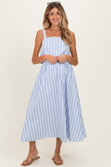woman wearing a light blue and white striped maternity sundress with buttons and a flowy skirt, standing and smiling