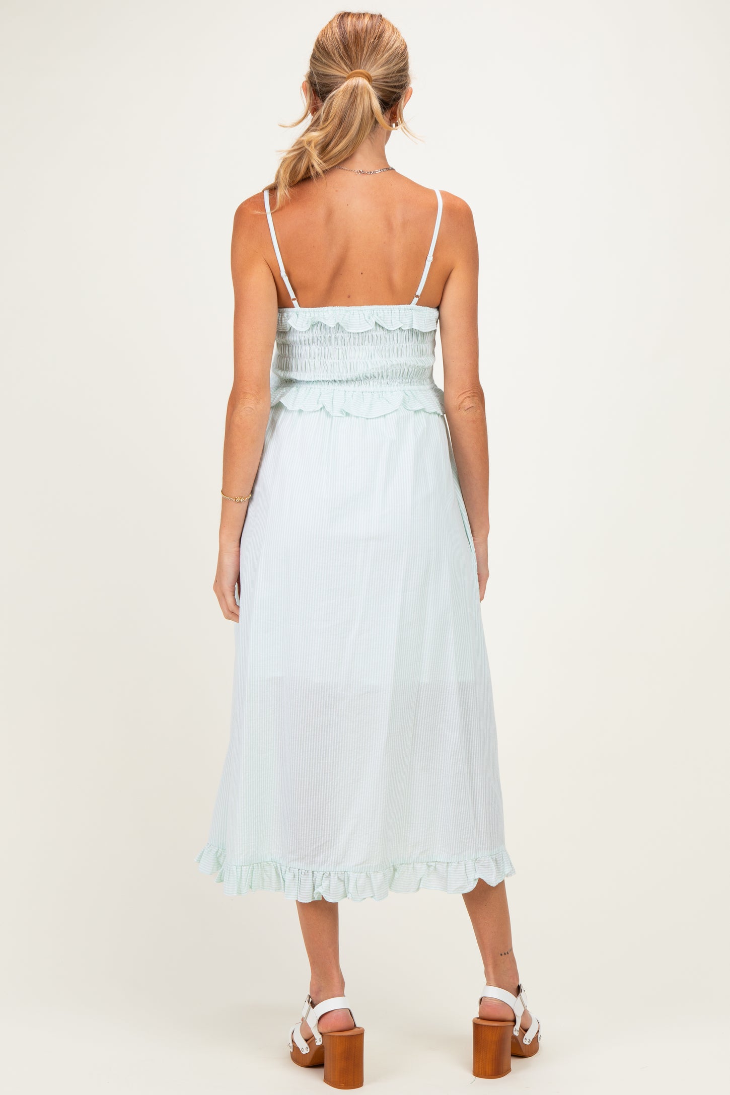 woman wearing a light green maternity maxi dress with a smocked bodice and ruffled hem, seen from the back