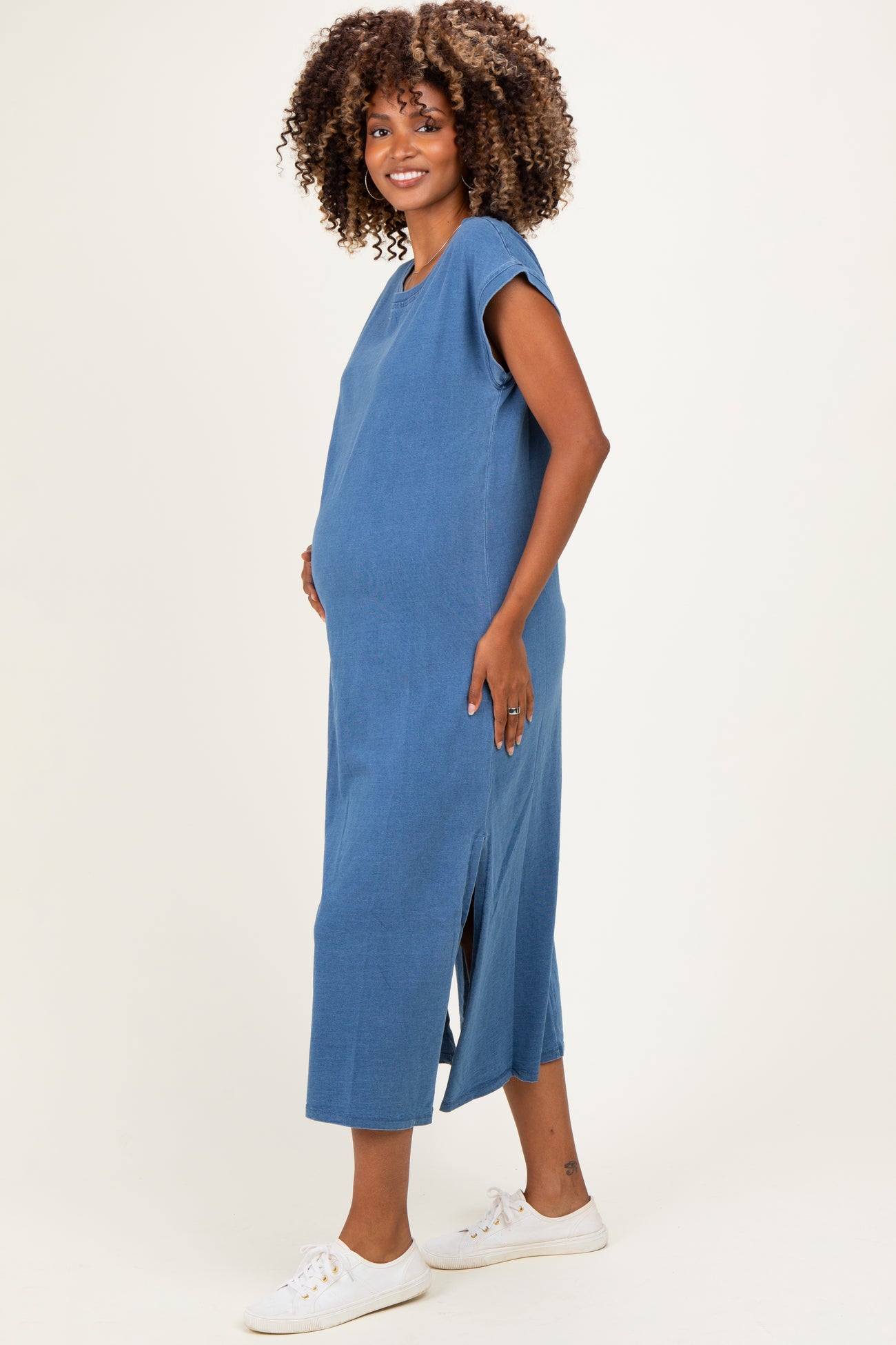 woman wearing a blue maternity maxi dress with short sleeves and side slits, highlighting her baby bump