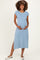 woman wearing a light blue maternity dress with short sleeves and a side slit, showing her baby bump