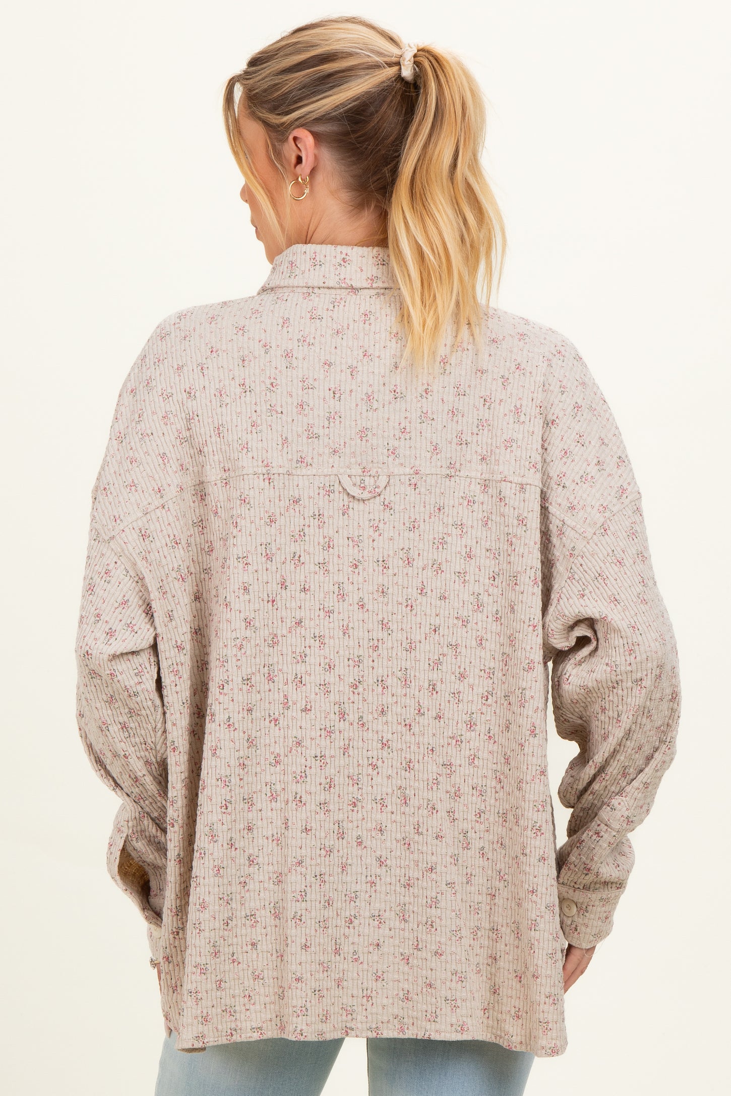 woman wearing a light beige floral patterned maternity cardigan with a relaxed fit and long sleeves
