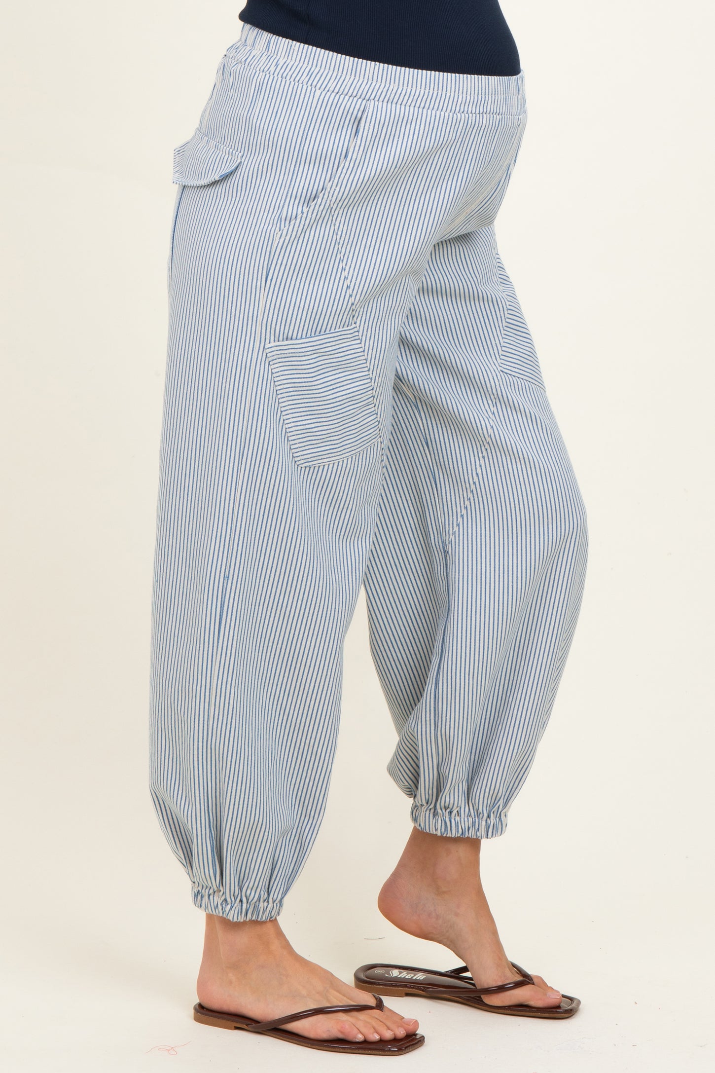 woman wearing light blue striped maternity harem pants with elastic cuffs and pockets, showcasing her baby bump