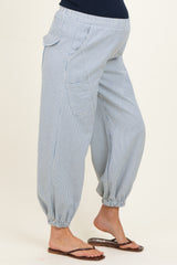 woman wearing light blue striped maternity harem pants with elastic cuffs and pockets, showcasing her baby bump
