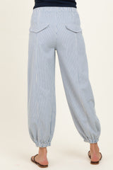 woman wearing light blue striped maternity pants with an elastic waistband and gathered cuffs, showing the back view