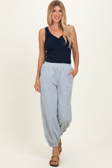 woman wearing a navy blue sleeveless top and light striped wide-leg pants with pockets