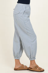 woman wearing blue and white striped cropped pants with elastic cuffs and side pockets, paired with tan sandals