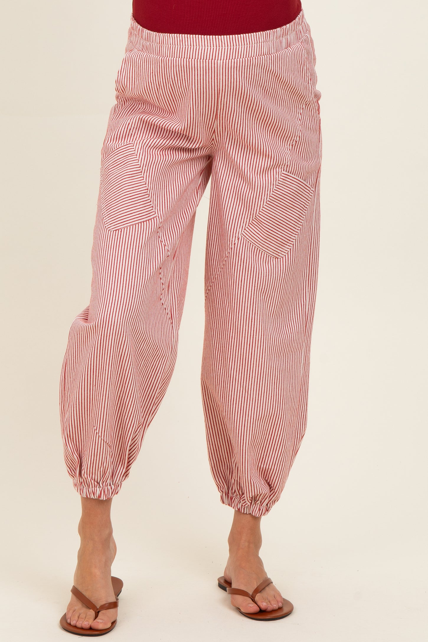 woman wearing red and white striped maternity pants with elastic waistband and relaxed fit