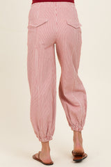 woman wearing red and white striped maternity pants with an elastic waist and tapered cuffs, viewed from the back