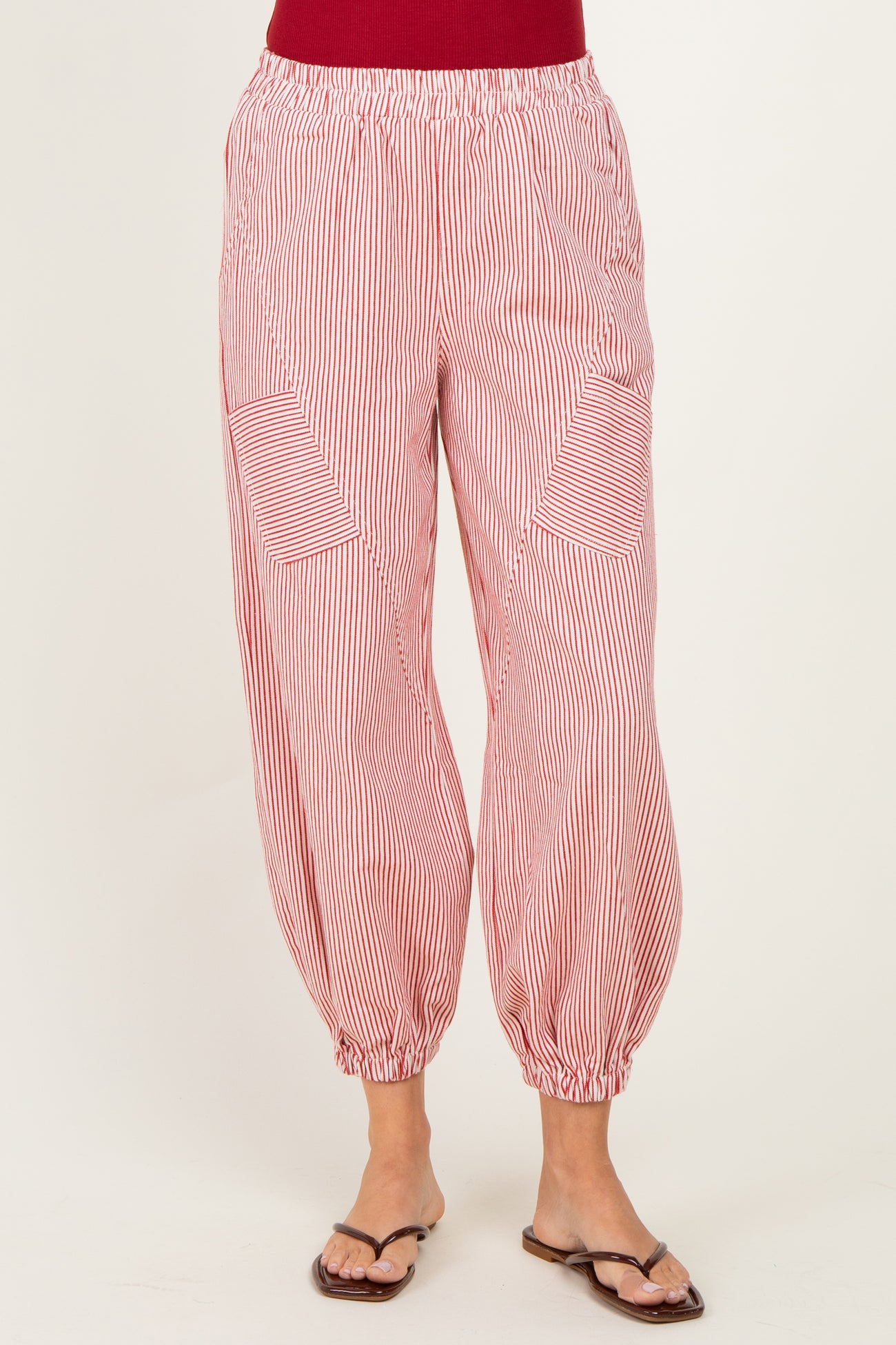 woman wearing red and white striped balloon pants with side pockets and elastic waistband