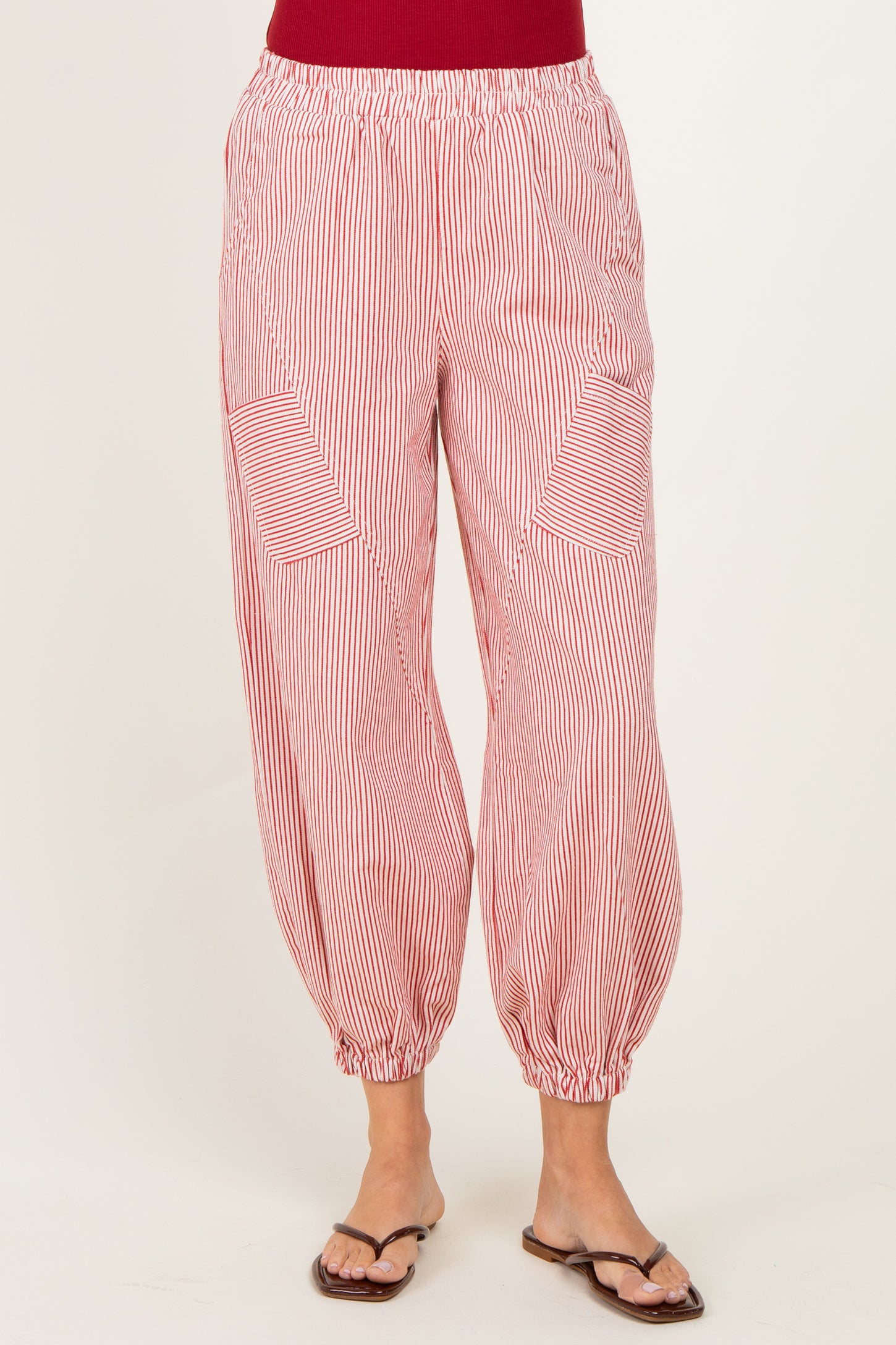 woman wearing red and white striped balloon pants with side pockets and elastic waistband