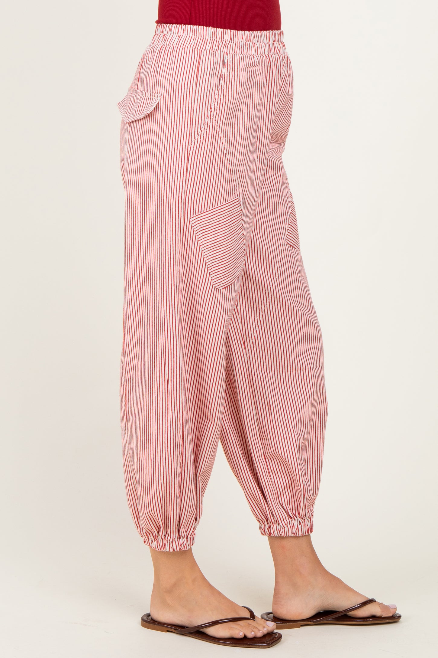 woman wearing red and white striped elastic waist pants with side pockets and gathered cuffs