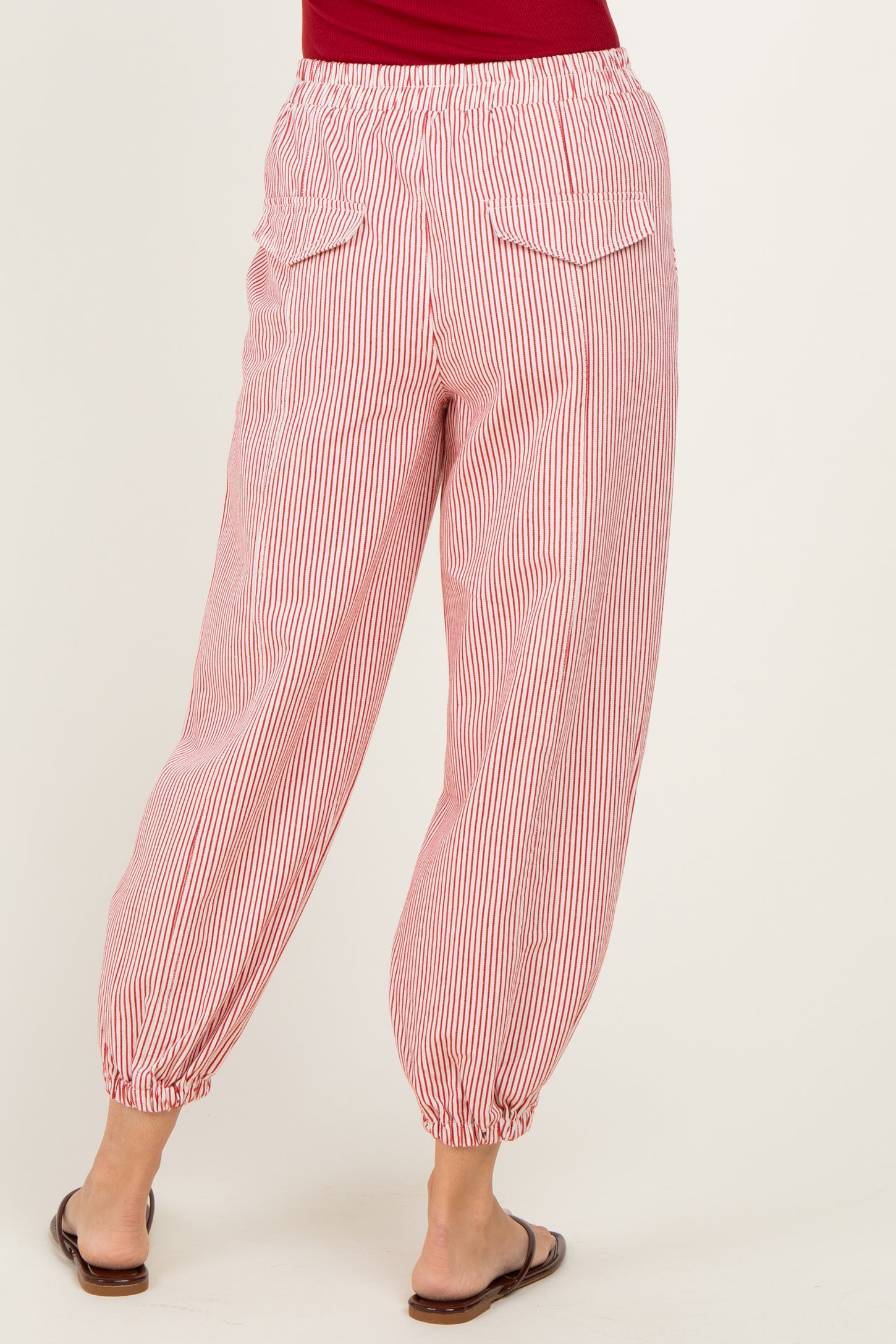 woman wearing red and white striped loose-fitting pants with elastic cuffs and back pockets