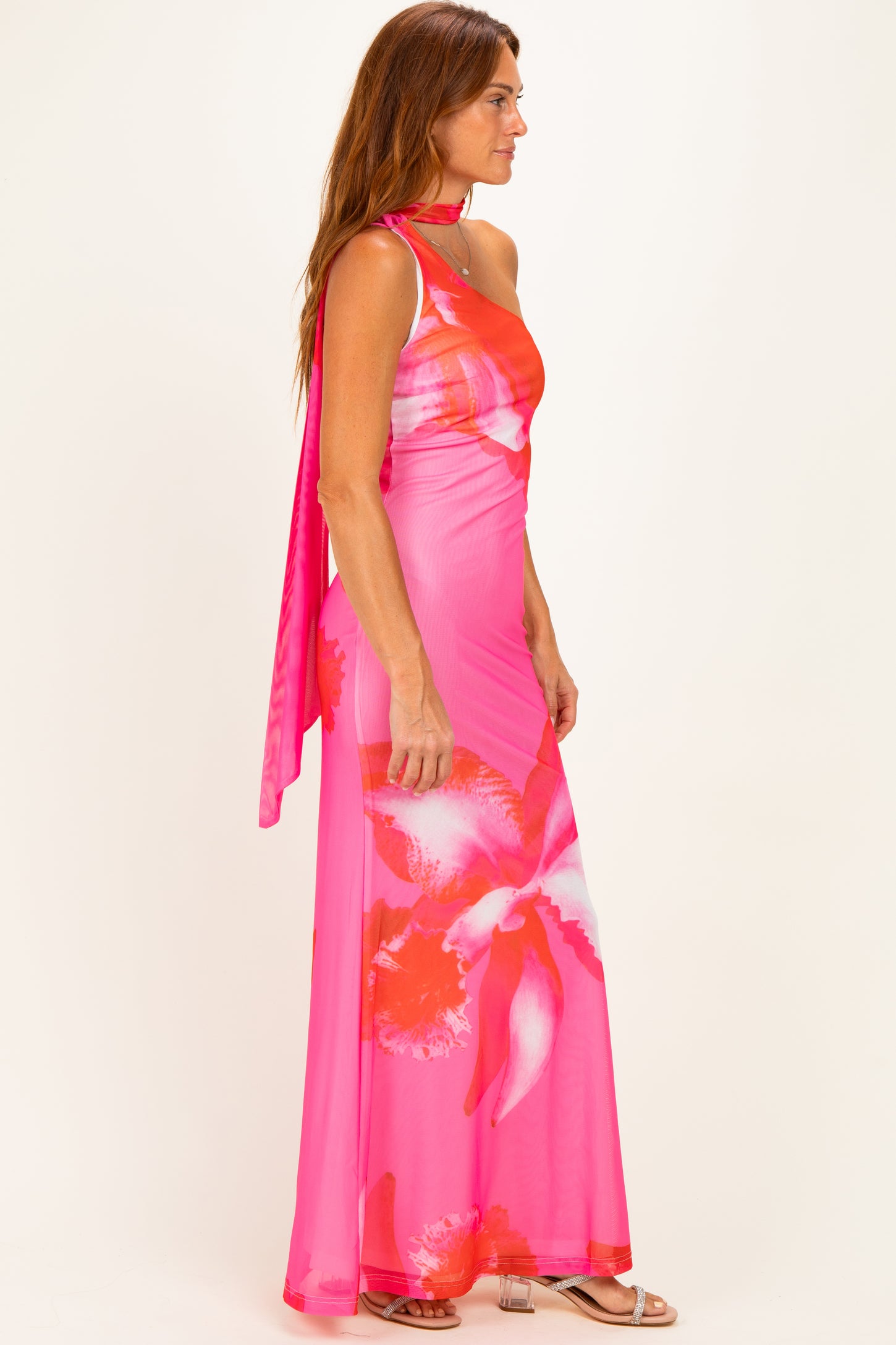 woman wearing a pink floral maxi dress with a halter neck and a matching scarf draped over her shoulder