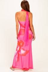 woman wearing a pink floral maxi dress with a halter neck and flowing silhouette, seen from the back