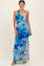 woman wearing a floral maxi dress in blue hues with a halter neckline and twist detail