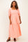 woman wearing a coral maxi dress with puff sleeves and floral embroidery details