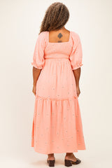 woman wearing a peach plus size maxi dress with puff sleeves and floral embroidery, view from the back