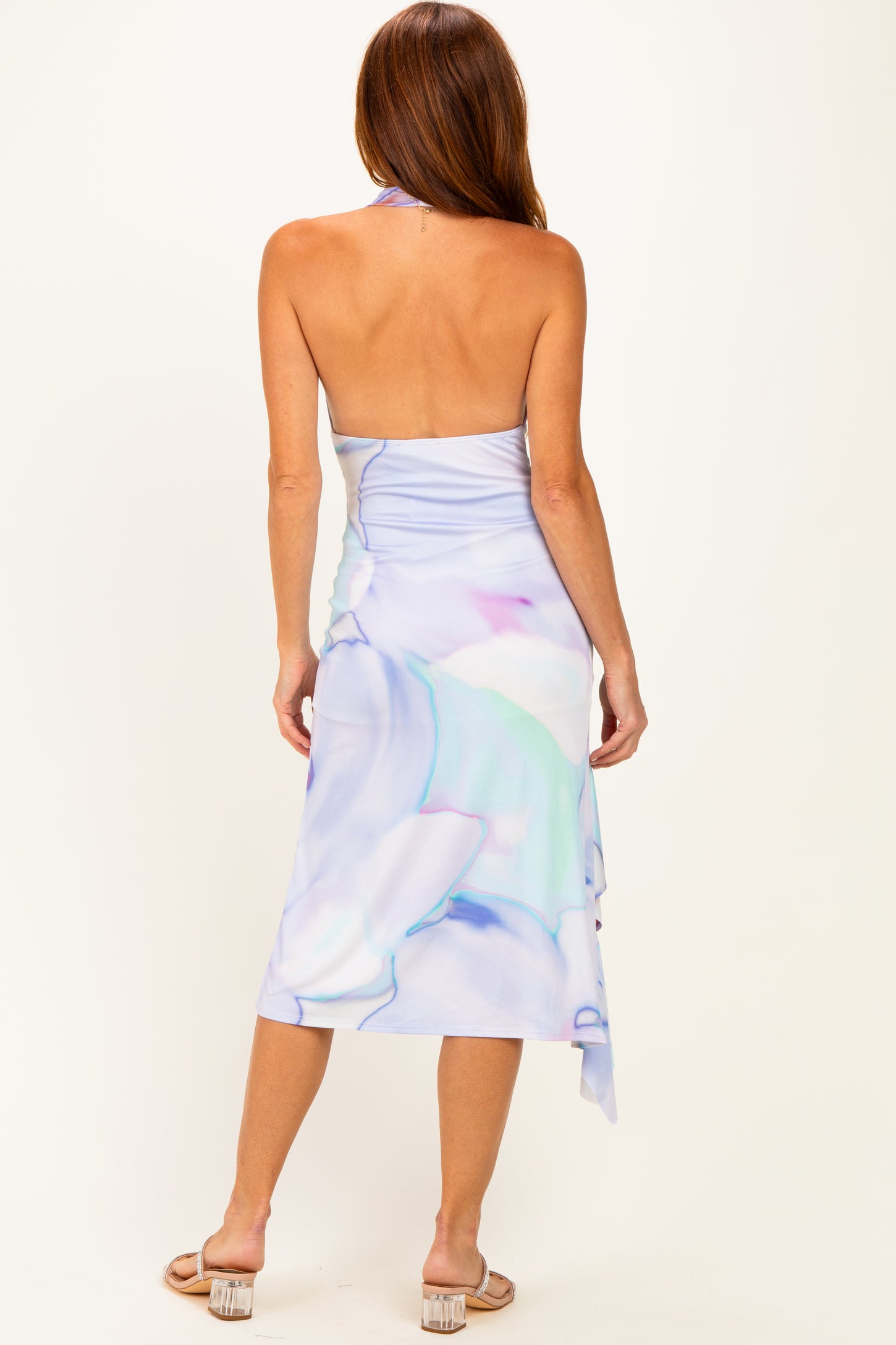 woman wearing a backless light blue floral midi dress with a halter neckline and a flowing skirt