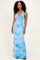 woman wearing a light blue halter neck maxi dress with a floral print and a fitted silhouette
