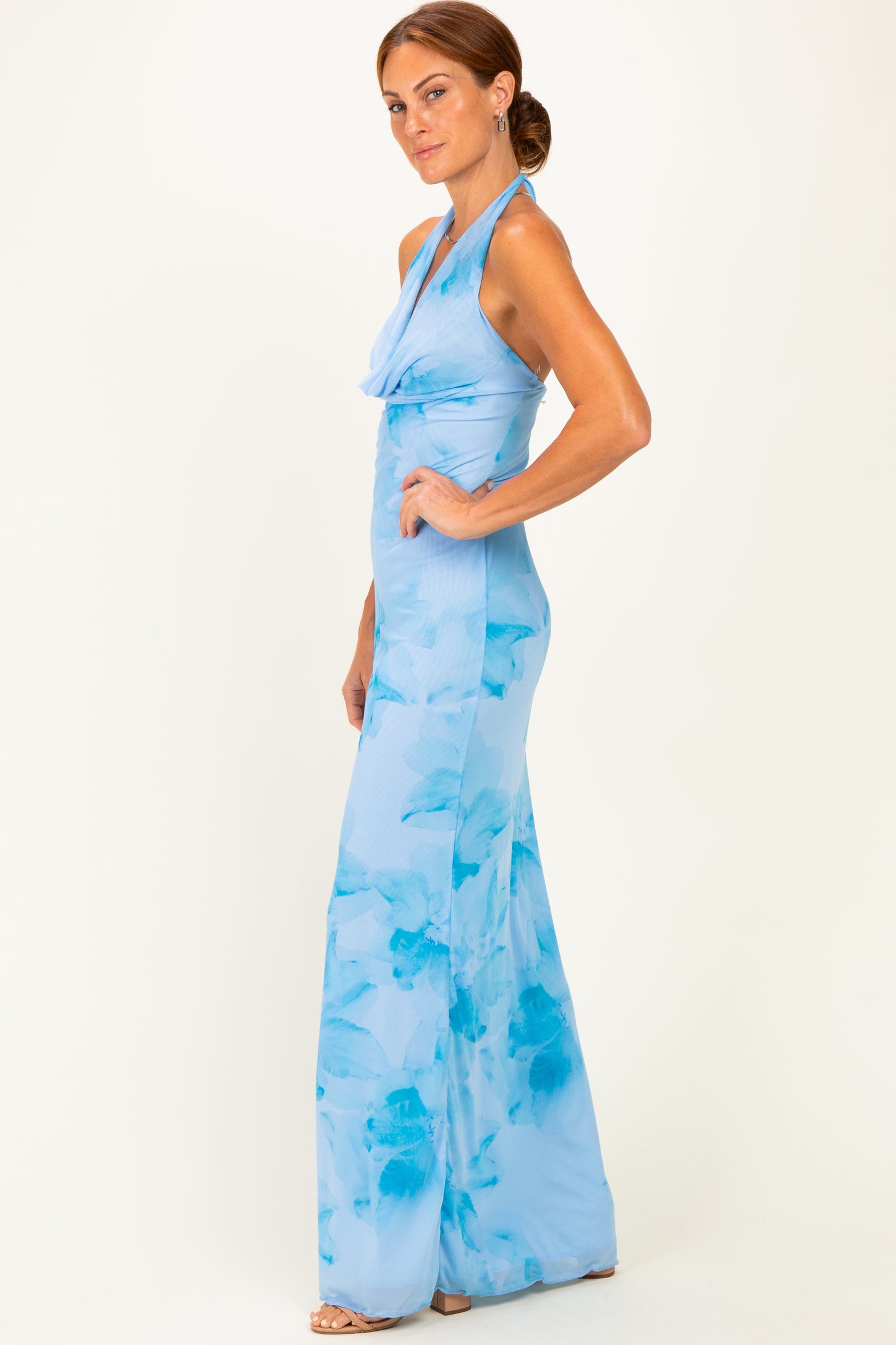 woman wearing a light blue floral halter neck jumpsuit with a fitted bodice and wide leg silhouette