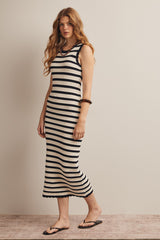 woman wearing a black and white striped ribbed midi dress with a fitted silhouette and sandals