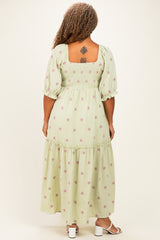 woman wearing a green floral printed plus size maxi dress with puff sleeves and a square back, showing a tattoo on her back