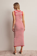 woman wearing a red and cream striped knit midi dress with a fitted silhouette and scalloped hem details, viewed from the back