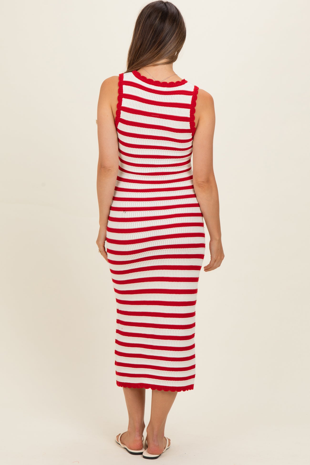 woman wearing a red and white striped maternity dress with a fitted silhouette and scalloped details