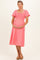woman wearing a pink smocked maternity dress with flutter sleeves and a visible baby bump