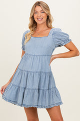 woman wearing a light blue tiered maternity dress with puff sleeves and a square neckline