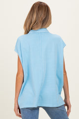 woman wearing a light blue short sleeve maternity top featuring a relaxed fit and back seam detail