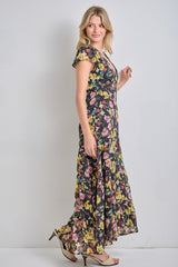 woman wearing a black floral maxi dress with cap sleeves and a flowing hemline