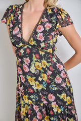 woman wearing a black floral wrap dress with cap sleeves and a deep v-neckline