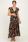 woman wearing a black floral maternity maxi dress and holding her baby bump