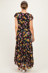 woman wearing a black floral maternity maxi dress with ruffle sleeves, showing the back view