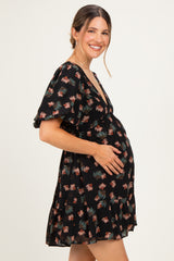 woman wearing a black floral maternity dress with short puff sleeves and a visible baby bump