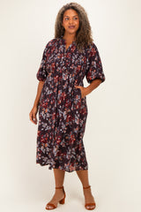 woman wearing a dark floral midi dress with a gathered neckline and short puff sleeves