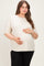 woman wearing a beige maternity plus oversized t-shirt with a visible baby bump and black leggings