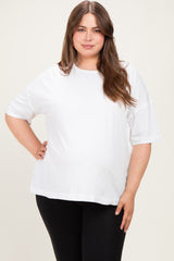 woman wearing a white maternity plus oversized t-shirt and black leggings, showing her baby bump