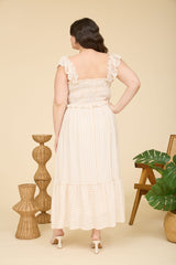 woman wearing a plus size striped maxi dress with a ruffled neckline and elastic waist, viewed from the back
