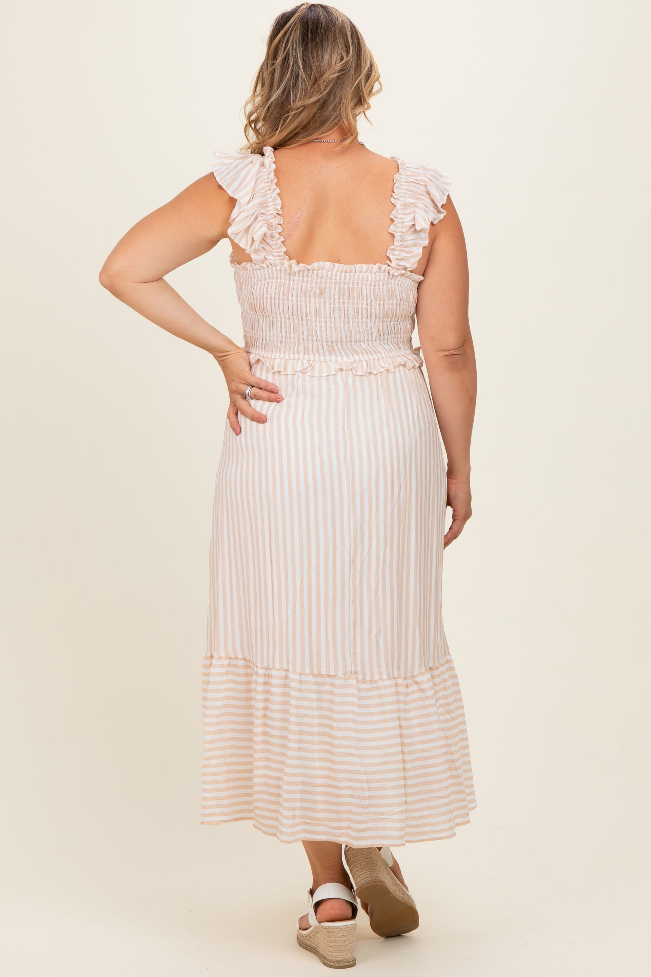 woman wearing a striped maternity plus maxi dress with ruffled straps and a smocked bodice, showing her back