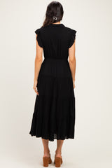 woman wearing a black tiered maxi dress with cap sleeves and a fitted waist, shown from the back