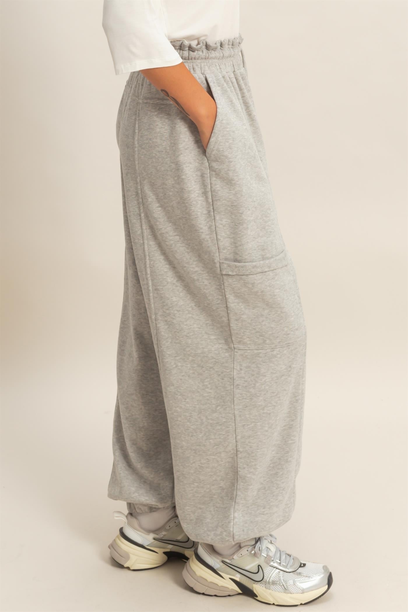 woman wearing gray wide-leg sweatpants with side pockets and an elastic waistband